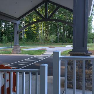 A serene view of a park entrance with a covered pavilion and lush greenery surrounding the area.