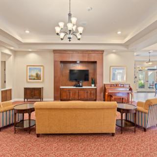 A welcoming lobby area featuring comfortable sofas, a television, and elegant lighting.