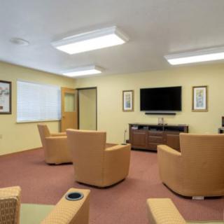 A cozy living room with comfortable chairs arranged around a television.
