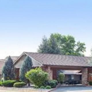 A suburban house with a driveway and surrounding greenery.