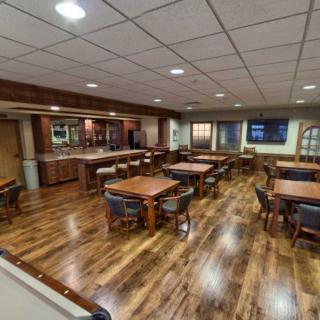 An inviting dining area with wooden flooring and neatly arranged tables and chairs.