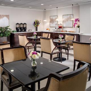 A cozy cafe interior with neatly arranged tables and chairs, adorned with floral decorations.