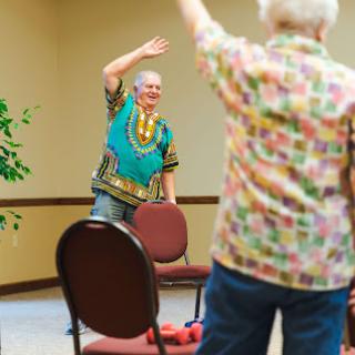 Seniors participating in a lively exercise session, promoting health and social interaction.