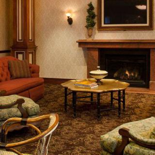 A cozy living room with a fireplace, featuring traditional furniture and decor.