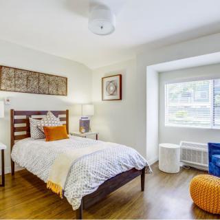 A cozy bedroom with bright decor and modern furnishings.