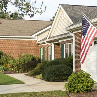 A suburban house with an American flag displayed near the entrance.