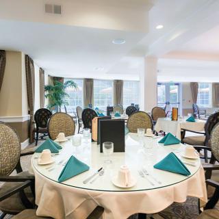 An elegantly set dining table in a restaurant with teal napkins and sophisticated decor.