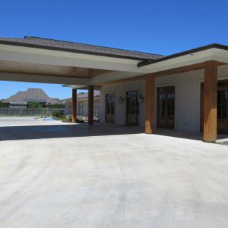 A modern house with a spacious driveway under a clear blue sky.