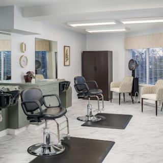 A modern hair salon featuring stylish furnishings and ample natural light.