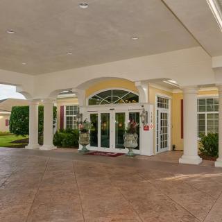 Elegant entrance with columns and glass doors.