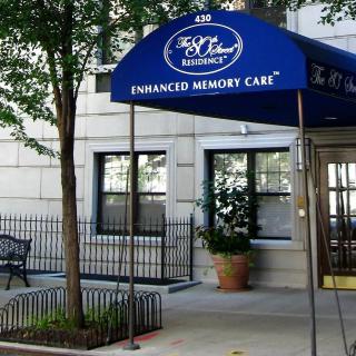 The entrance to a memory care facility with a blue awning.