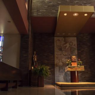 A serene church interior featuring an elegant altar and religious artwork.