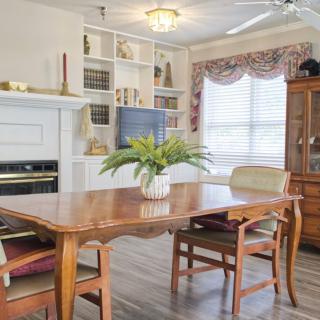 A cozy dining room with a wooden table, chairs, and built-in shelves.