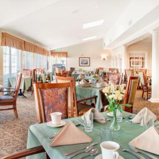 An elegantly set dining room with neatly arranged tables and chairs in a well-lit interior.