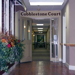 Entrance to Cobblestone Court with decorative flower arrangement.