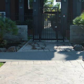 A gated entrance to a residential property with a landscaped pathway.