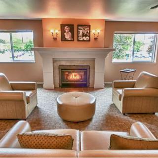 A cozy living room with elegant seating around a warm fireplace.