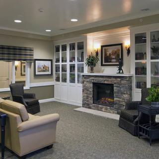 A cozy living room featuring a fireplace, comfortable seating, and decorative art.