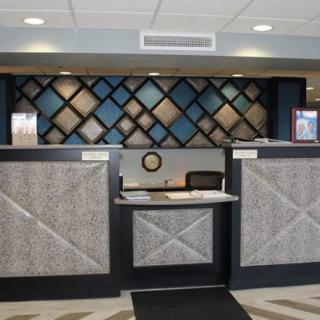 A modern hotel reception desk with stylish geometric wall patterns.