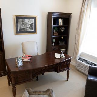 A well-organized office space with a desk, chair, and bookshelf.