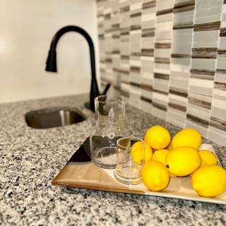 A stylish kitchen setup featuring fresh lemons and elegant glassware on a granite countertop.