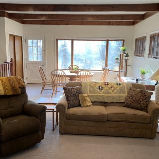 A cozy living and dining area with comfortable seating and large windows.