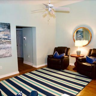 A cozy living room with leather armchairs, a striped rug, and stylish decor.