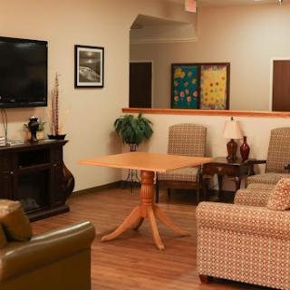 A cozy living room setup featuring comfortable seating, a wooden table, and decorative elements.