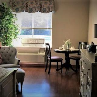 A cozy living room with a table and chairs by the window.