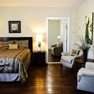 A cozy bedroom with a large bed, armchairs, and elegant decor.