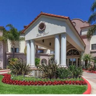 Elegant hotel entrance with landscaped gardens and classic architectural design.