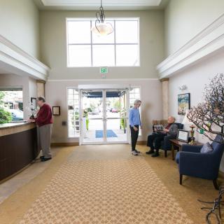 A spacious lobby with people checking in and waiting.