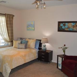 A cozy and well-decorated bedroom featuring a comfortable bed, stylish decor, and warm lighting.