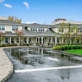 A large residential building with a driveway and landscaped surroundings.