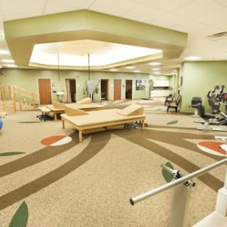 A spacious fitness and rehabilitation center, equipped with various exercise stations and a welcoming atmosphere.