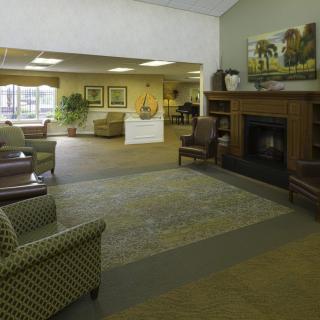 A spacious lobby area featuring comfortable seating, a fireplace, and decorative elements.