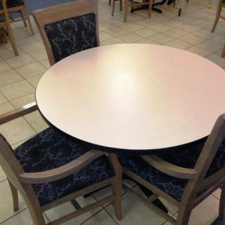 A round table with three chairs in an indoor setting.