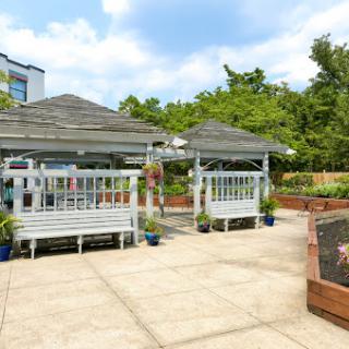 A serene outdoor space featuring two gazebos surrounded by greenery.
