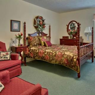 A traditionally decorated bedroom with a wooden bedframe and floral-themed bedding.