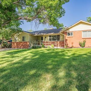 A charming ranch-style house with a well-maintained front lawn and mature trees.