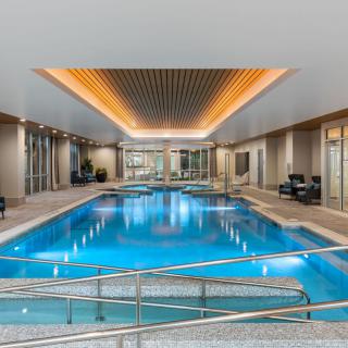 A luxurious indoor swimming pool with modern design and ambient lighting.