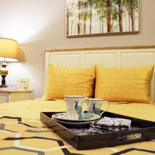 A cozy bedroom with yellow bedding and stylish decor.