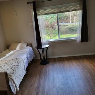 A minimalist bedroom with a single bed and large window.