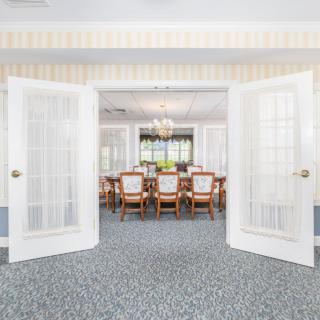 Spacious dining room with open double doors and elegant decor.