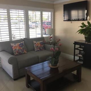 A cozy living room with a sofa, coffee table, and wall-mounted TV.