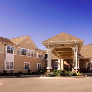 A welcoming entrance to a residential building under a clear blue sky.