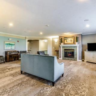 A spacious living room featuring a modern sofa, a cozy fireplace, and a television.