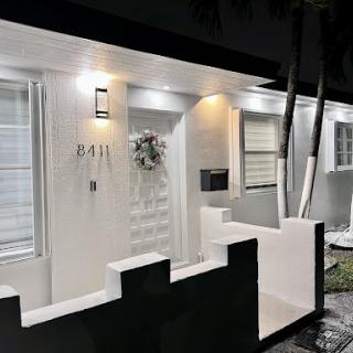 A beautifully designed modern home entrance illuminated at night.