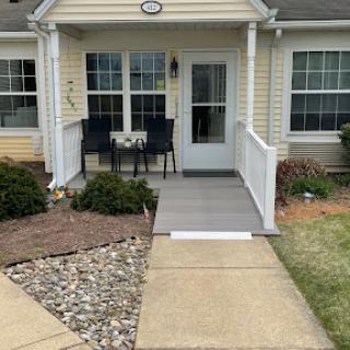 A welcoming front porch with outdoor seating, surrounded by well-maintained landscaping.