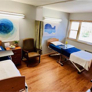 A bright and inviting hospital room designed for patient comfort, featuring two beds and cheerful artwork.